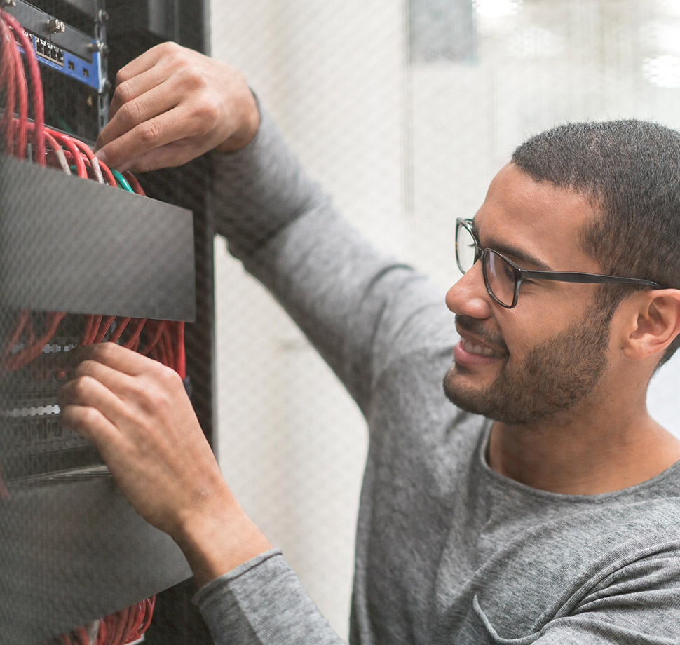 DSL vs. Kabel-Internet: Die Unterschiede. Das Artikelbild zeigt einen Techniker beim Anschluss von Kabeln an einen Server.