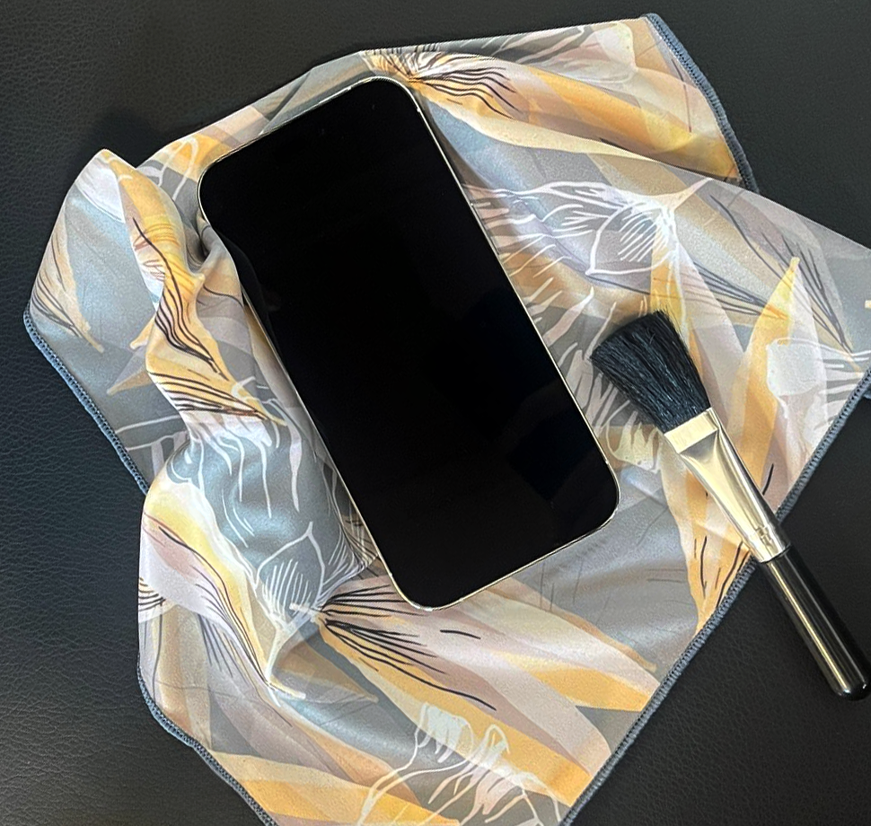 Ein Smartphone lieg auf einem Mikrofasertuch. Daneben befindet sich ein Pinsel zum säubern