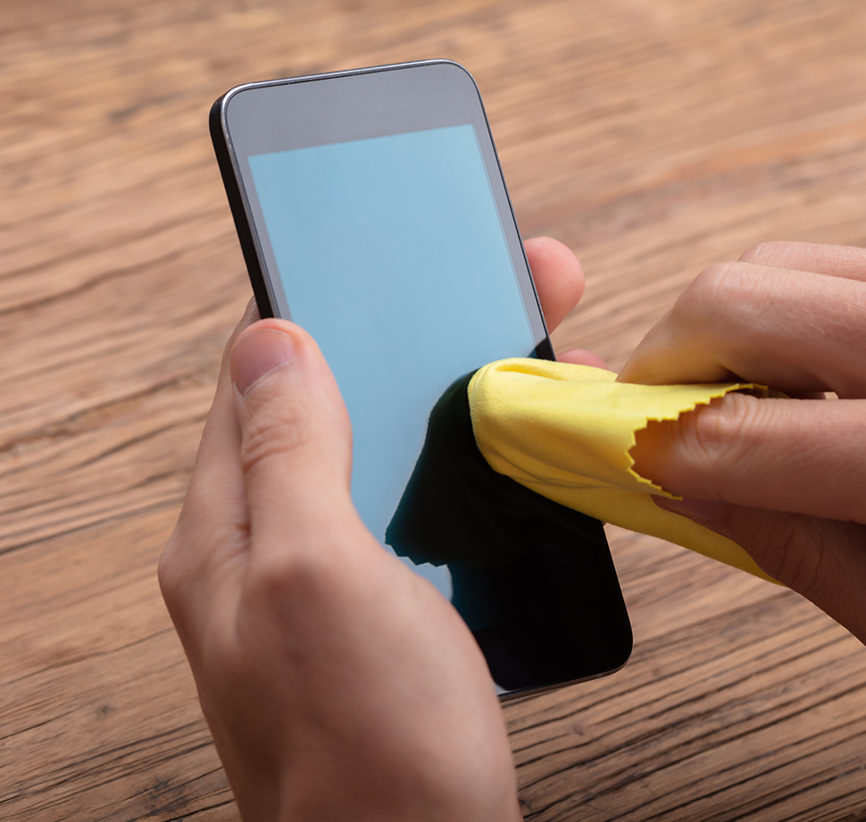 Ein Smartphone wird mit einem Mikrofasertuch gereinigt.
